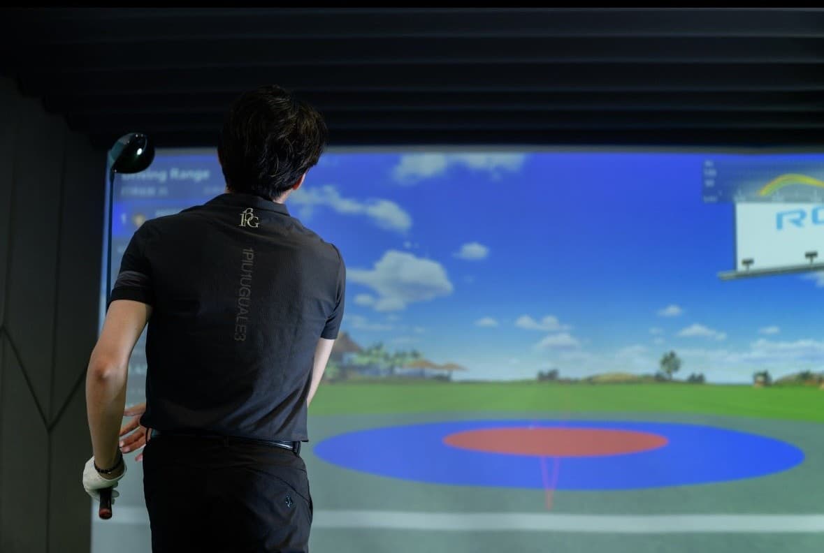 A golfer at the simulator, seen from behind